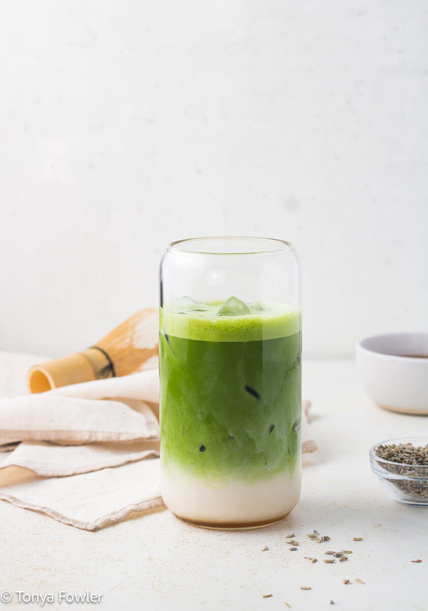 Straight on view of a matcha latte in a glass.