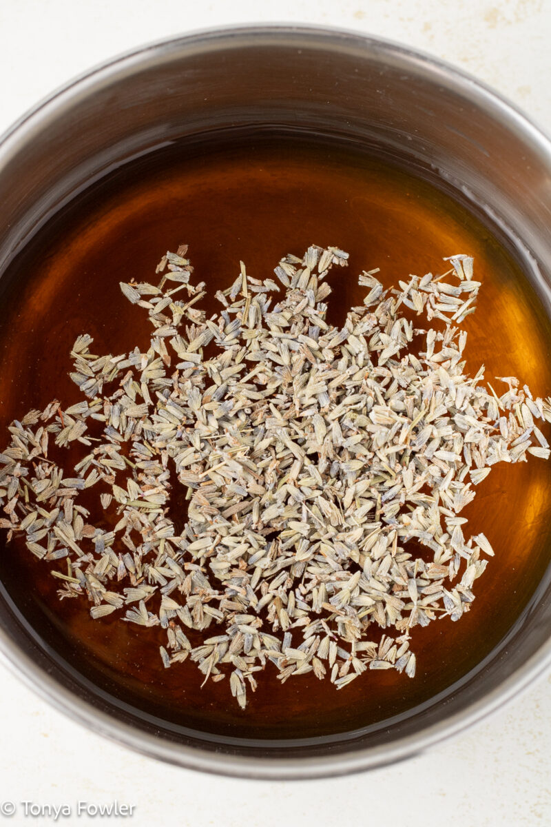 Close up image of lavender buds and honey in a sauce pot. 