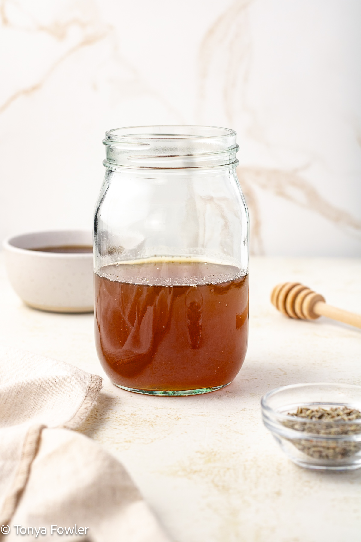 Side view of honey lavender syrup in a mason jar.