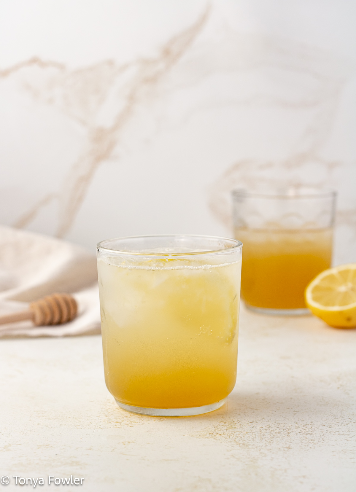 Straight on view of citrus honey mocktail in glasses.
