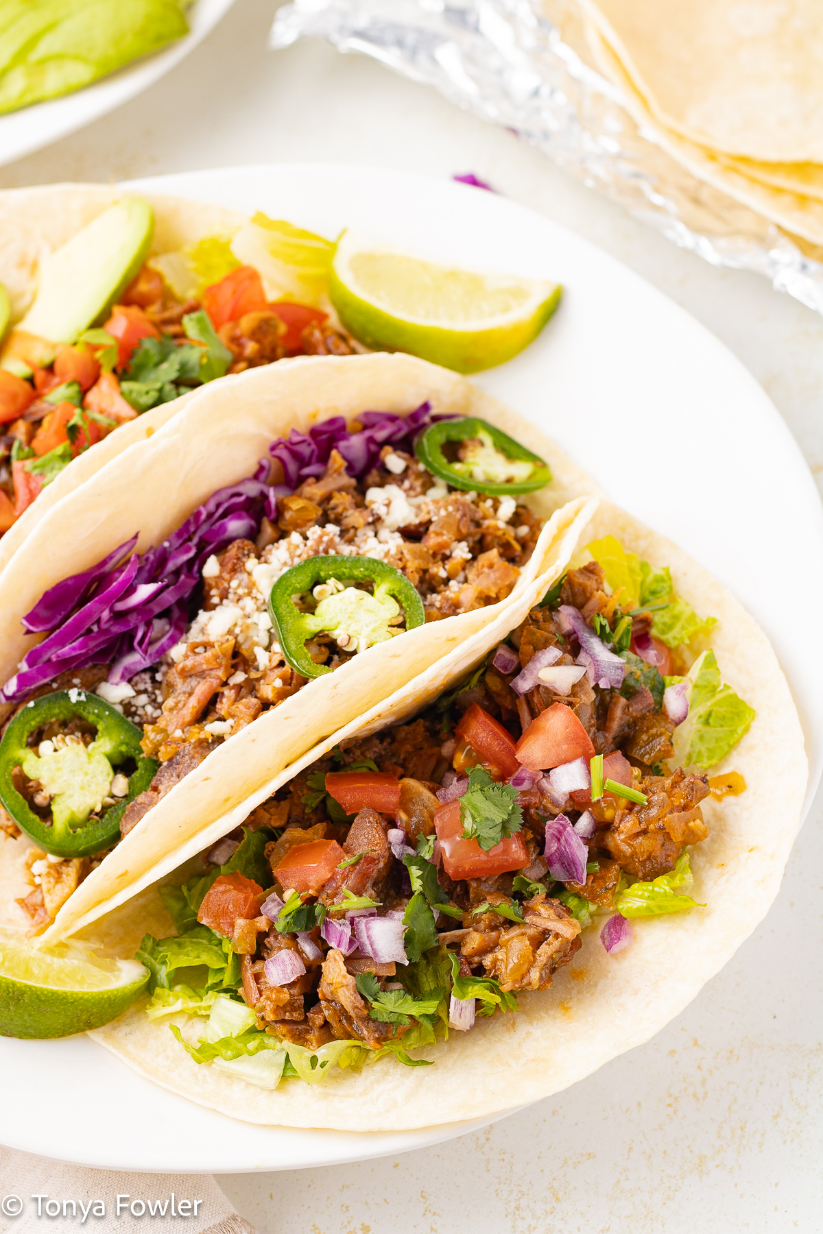 3/4 view of beef tacos on a plate. 