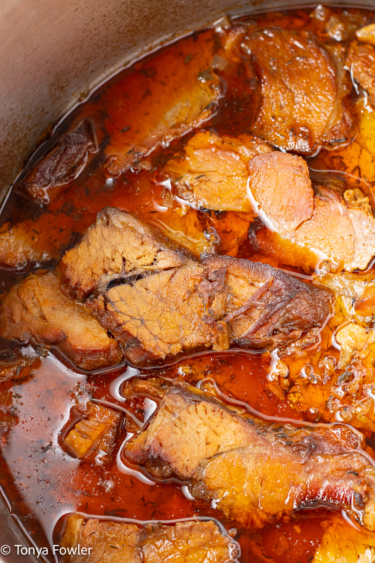Close up image of slices of beef in a pot.