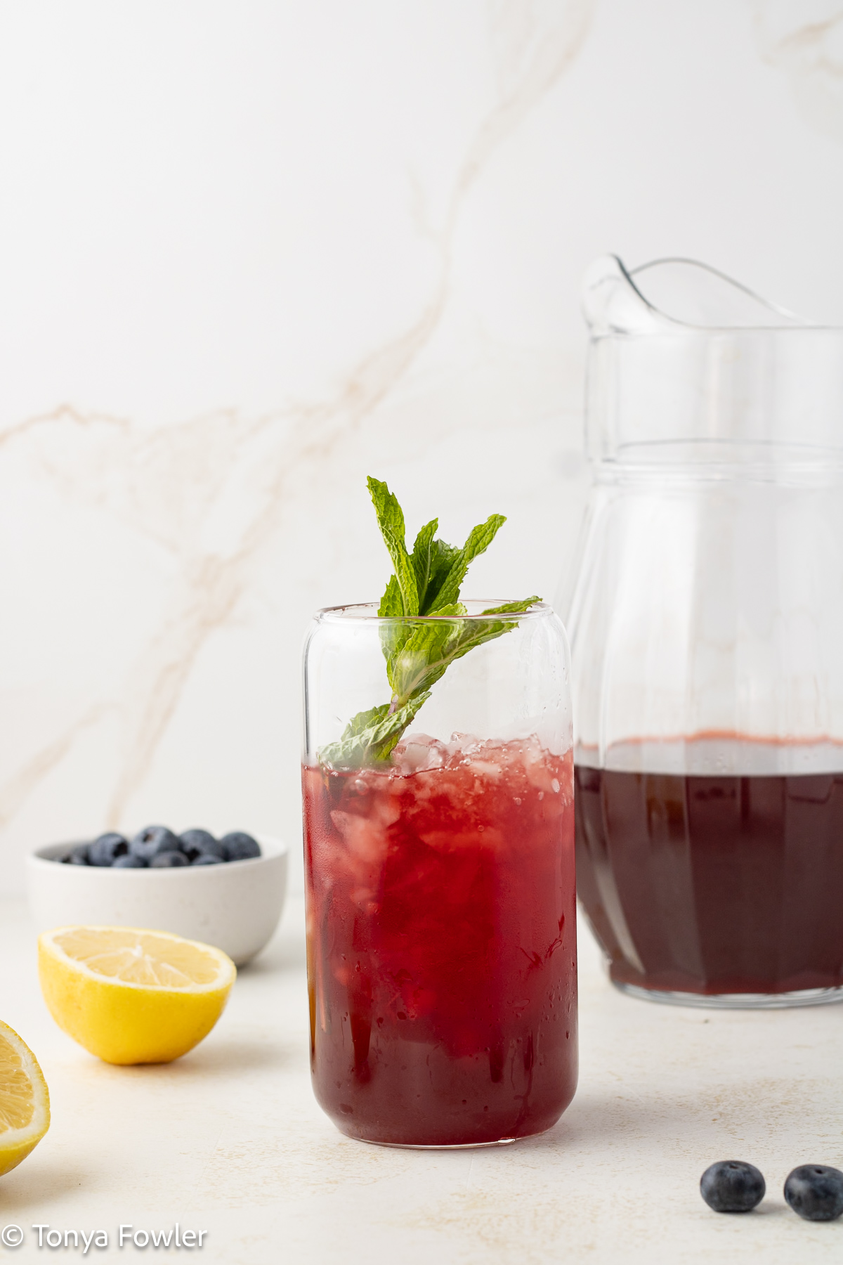 Straight on view of iced tea in a glass with fresh mint.