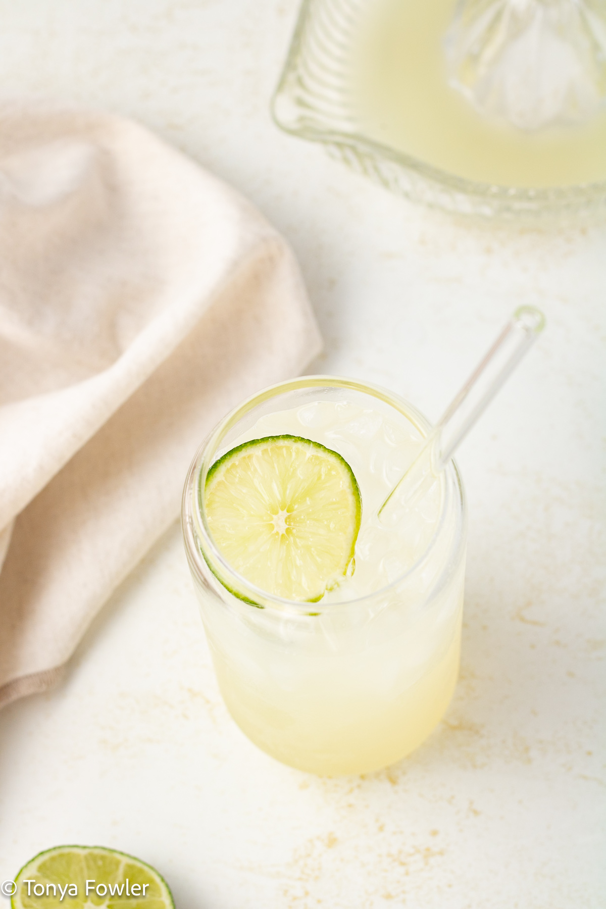 3/4 view of a glass of sparkling limeade with a lime slice on top.