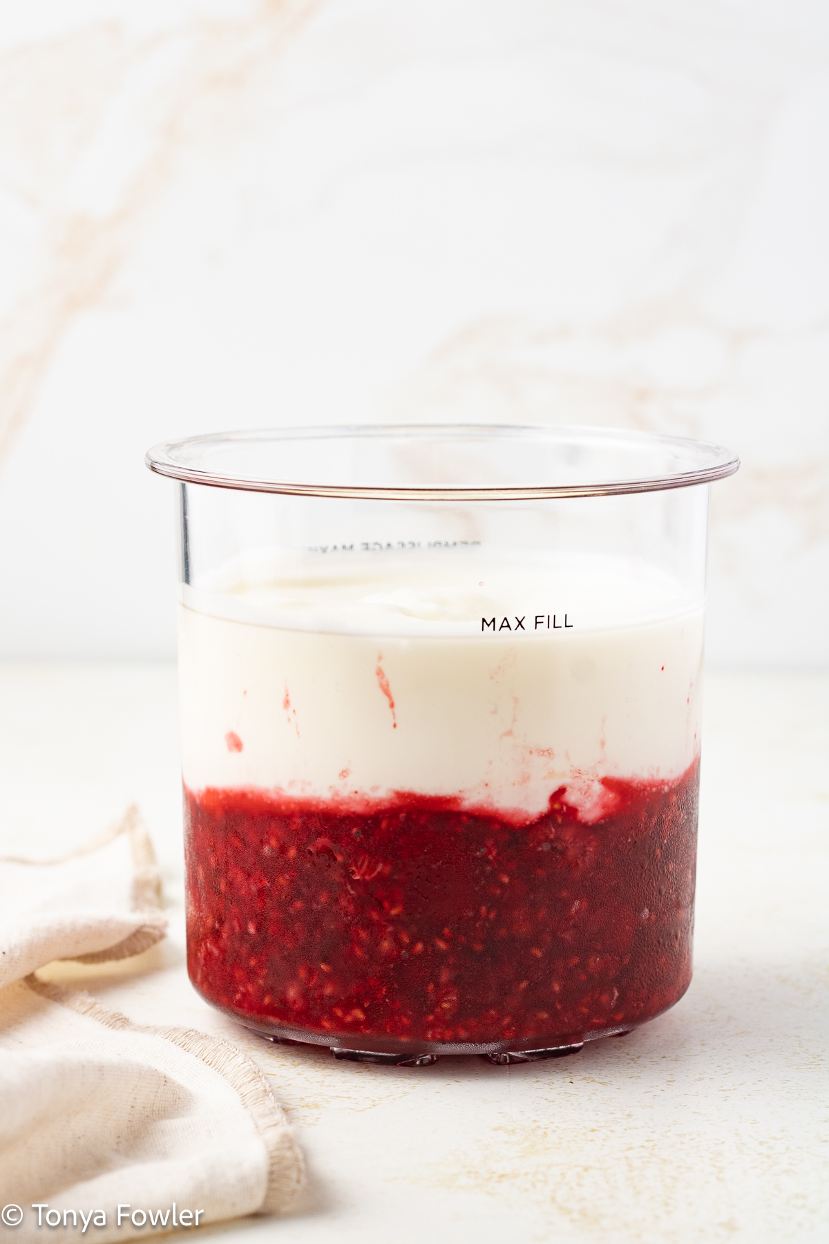 Raspberry puree and yogurt in a pint container.