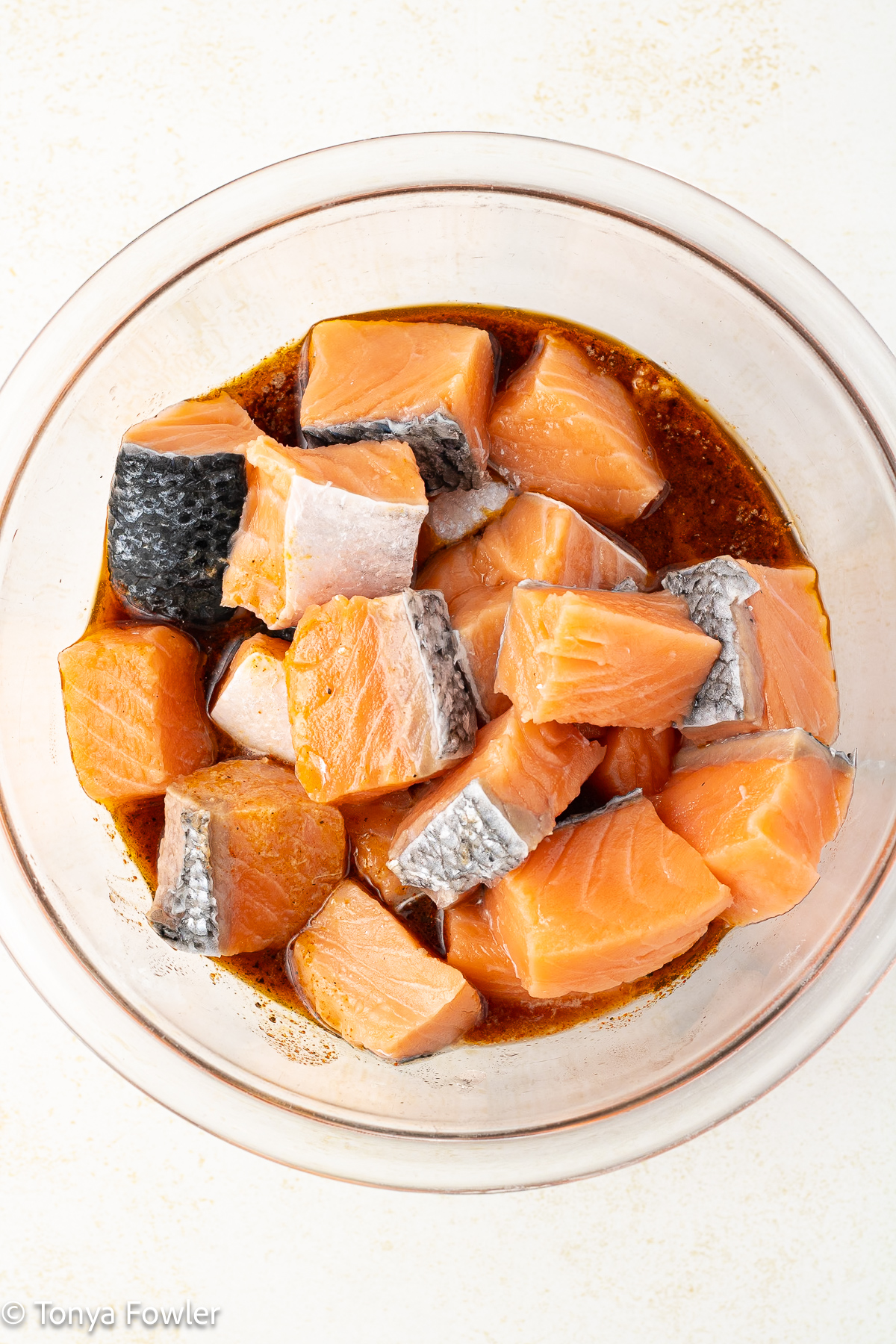 Raw salmon in a bowl with marinade.