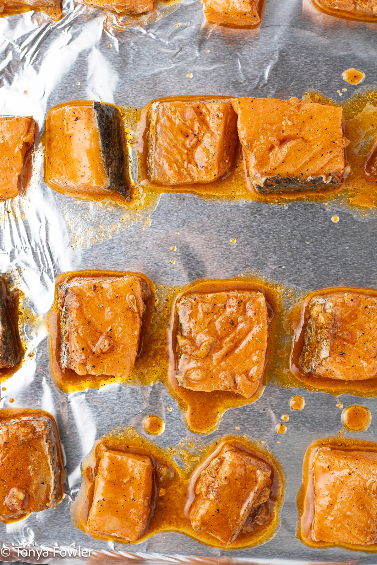 Marinaded salmon nuggets on a sheet pan.
