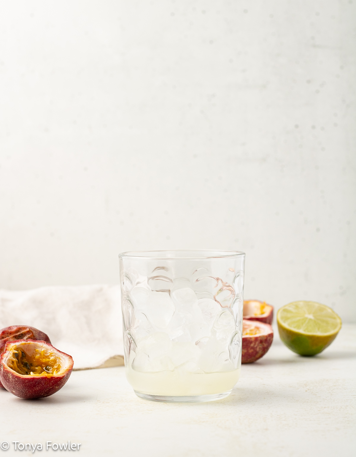 A glass filled with ice and lime juice.