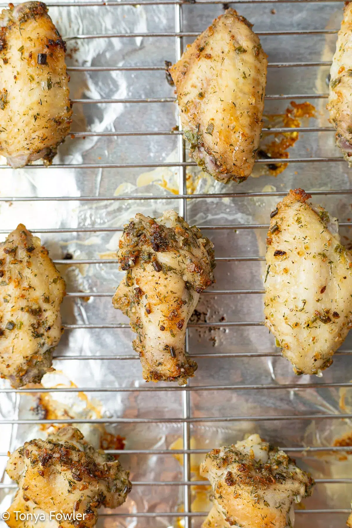 Baked chicken wings on a wire rack.
