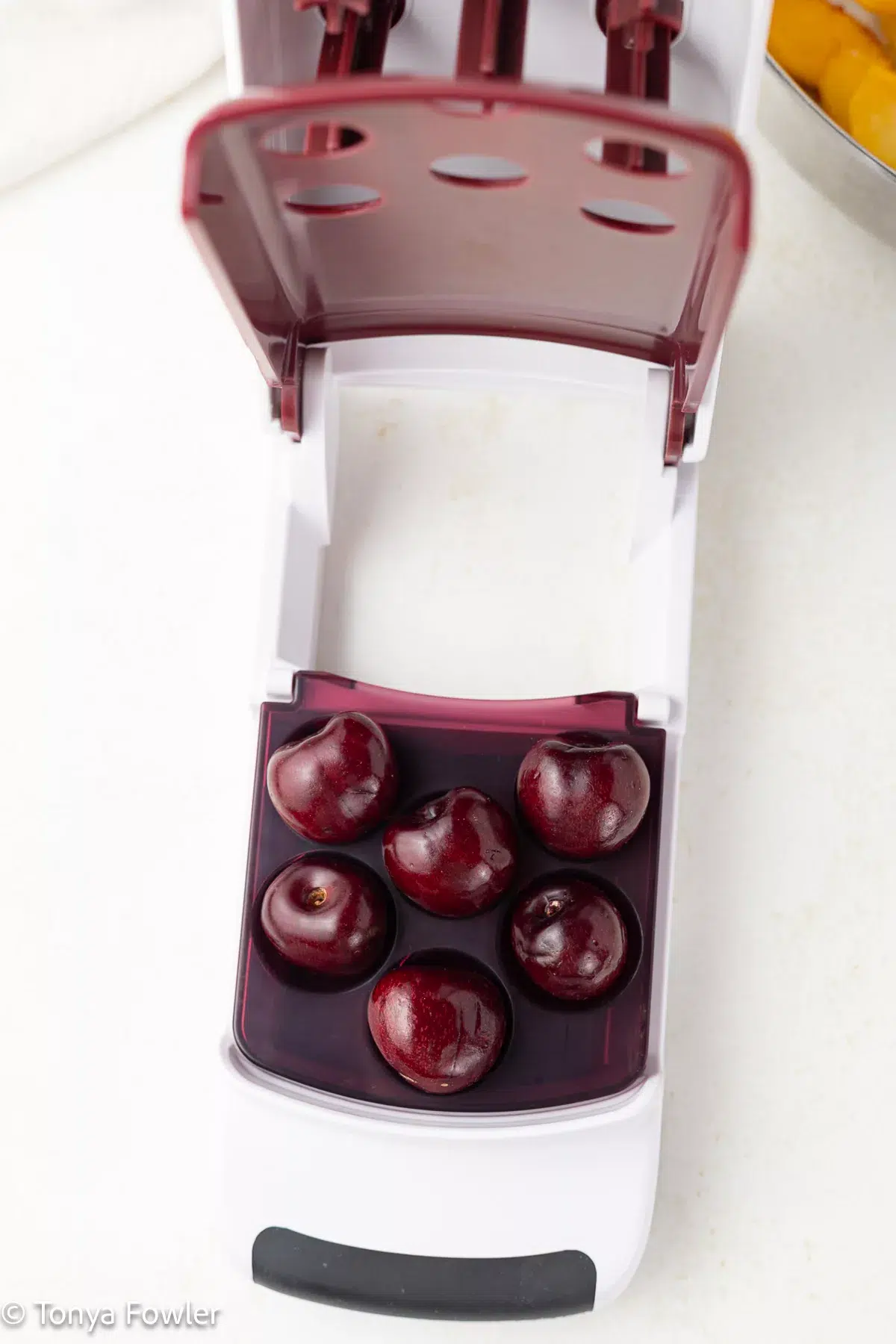 Cherries in a cherry pitter.