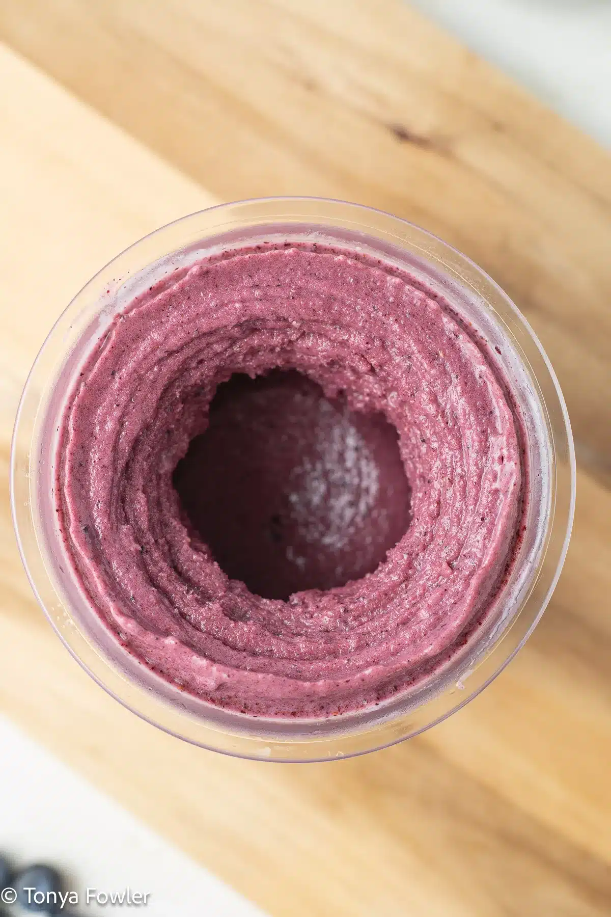 Overhead view of a blended fruit yogurt in a container.