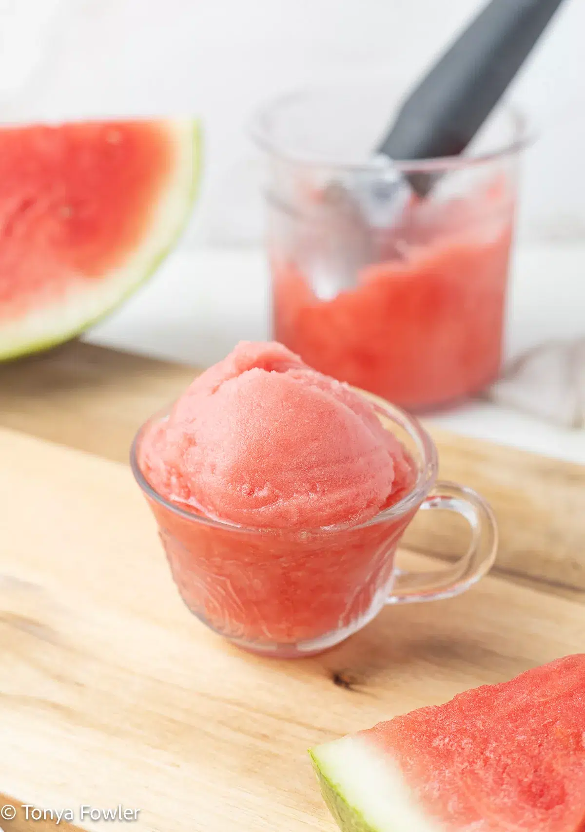 3/4 image of Ninja Creami Watermelon Sorbet in a cup with watermelon slices near by.