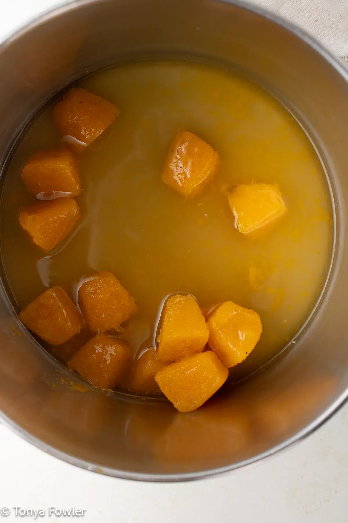 Frozen passion fruit chunks in a pot with sugar and water.
