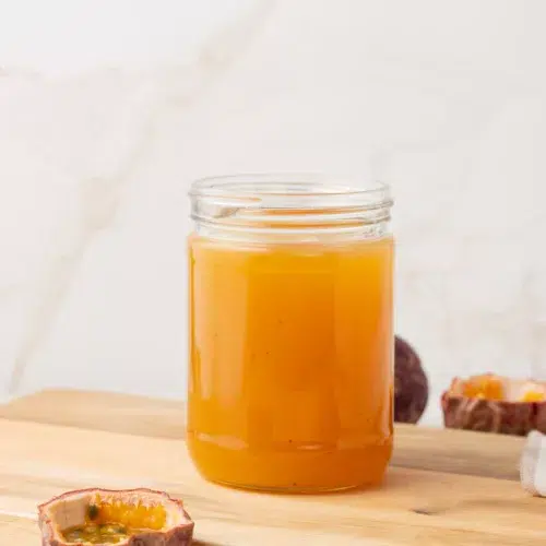 Straight on view of passionfruit syrup in a jar.