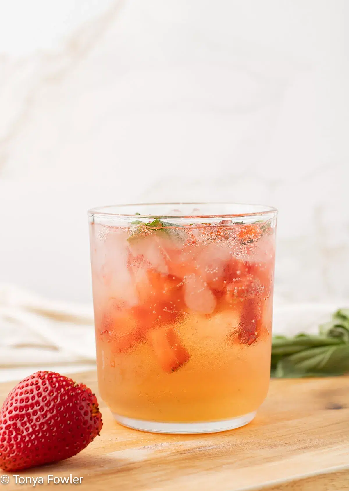 Straight on view of a mocktail with chopped strawberries. 