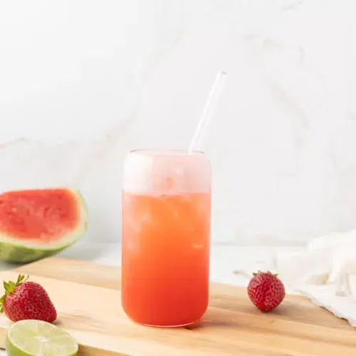 Strawberry Watermelon Mocktail in a glass with fresh fruit all around.