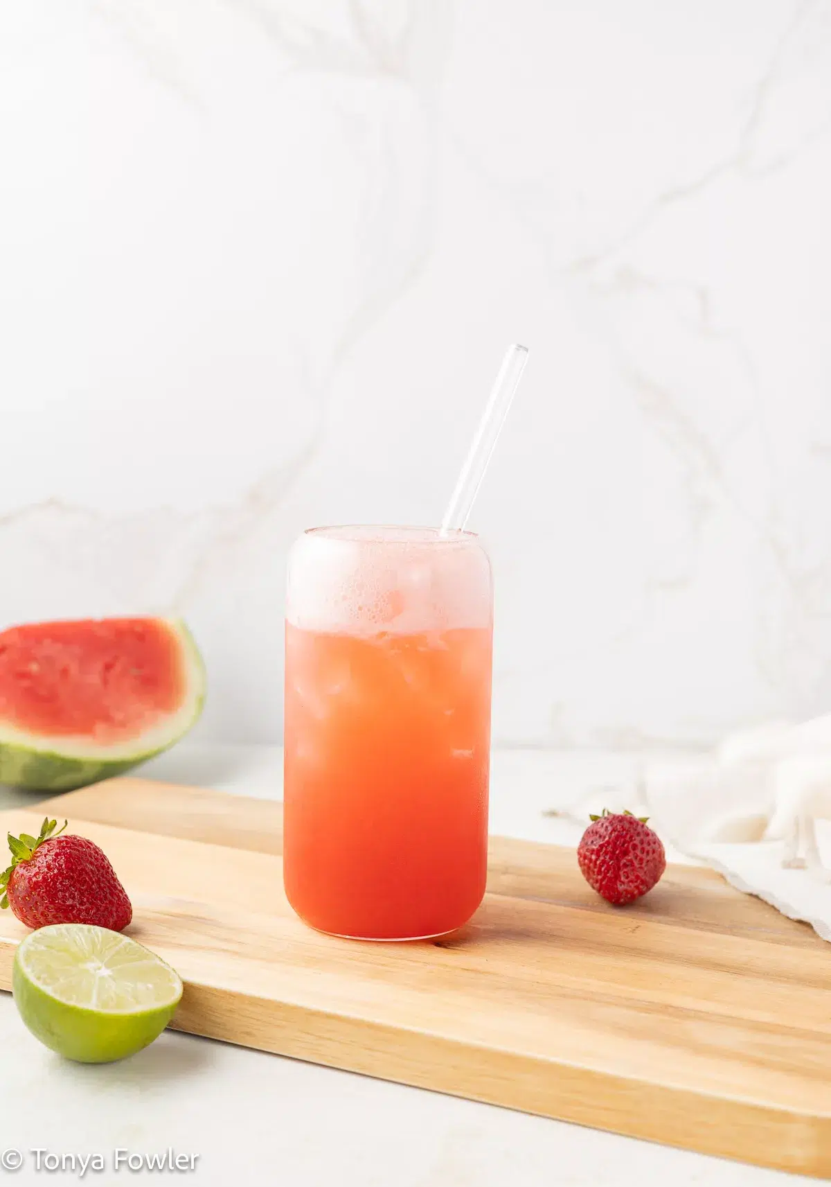 Strawberry Watermelon Mocktail in a glass with fresh fruit all around.