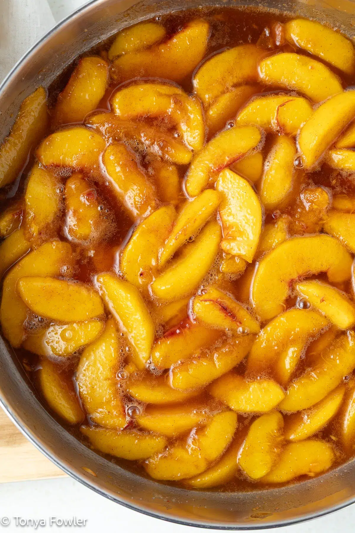Cooked peaches in a skillet.