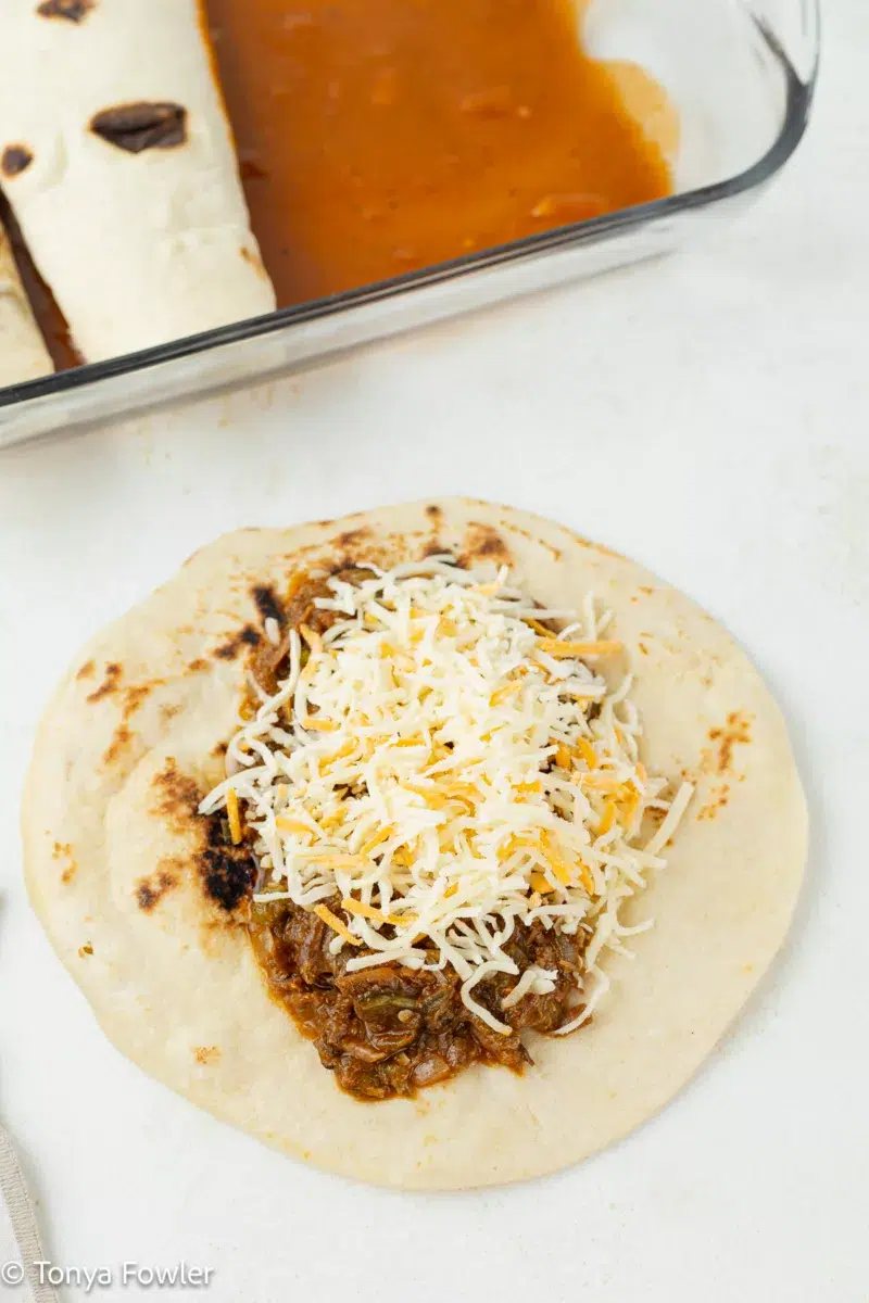 Tortilla topped with meat and cheese.