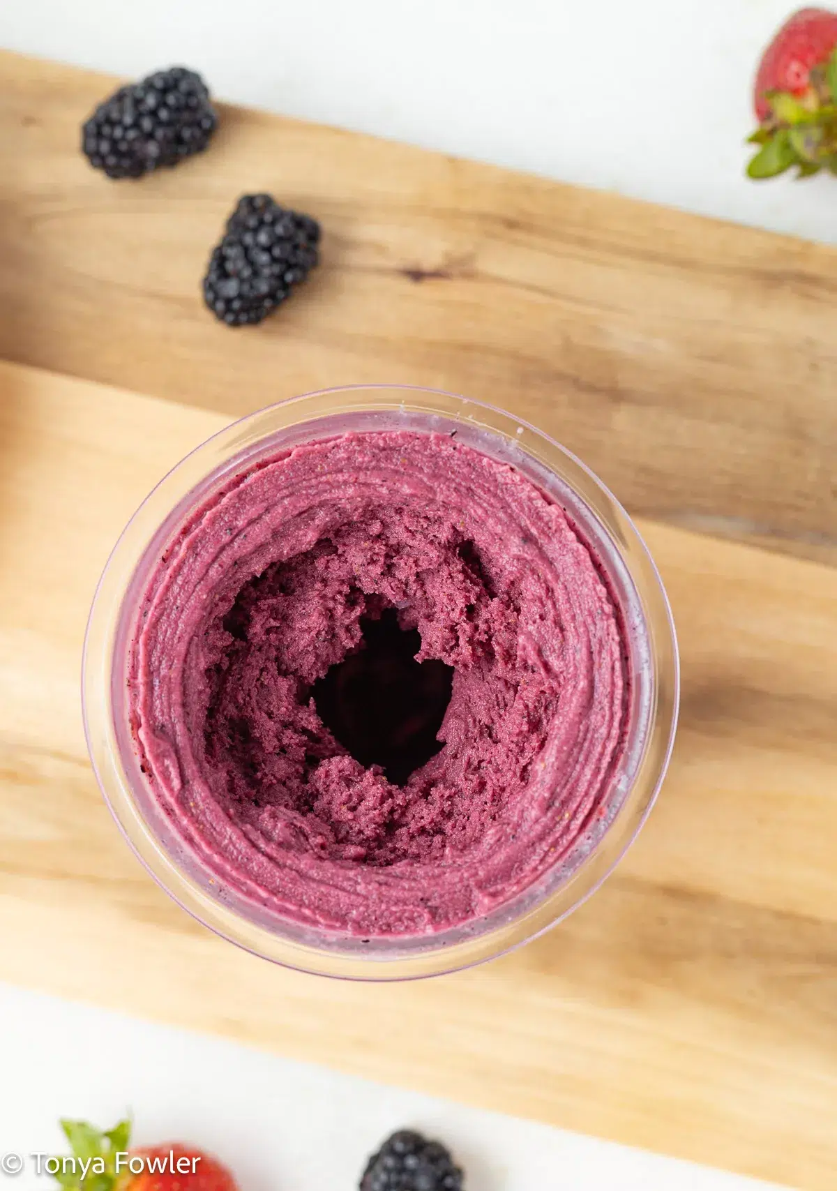 Blended berry frozen yogurt in a pint container.