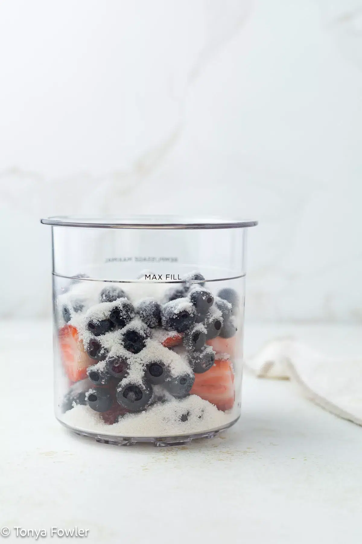 Frozen fruit in a pint container with sugar.