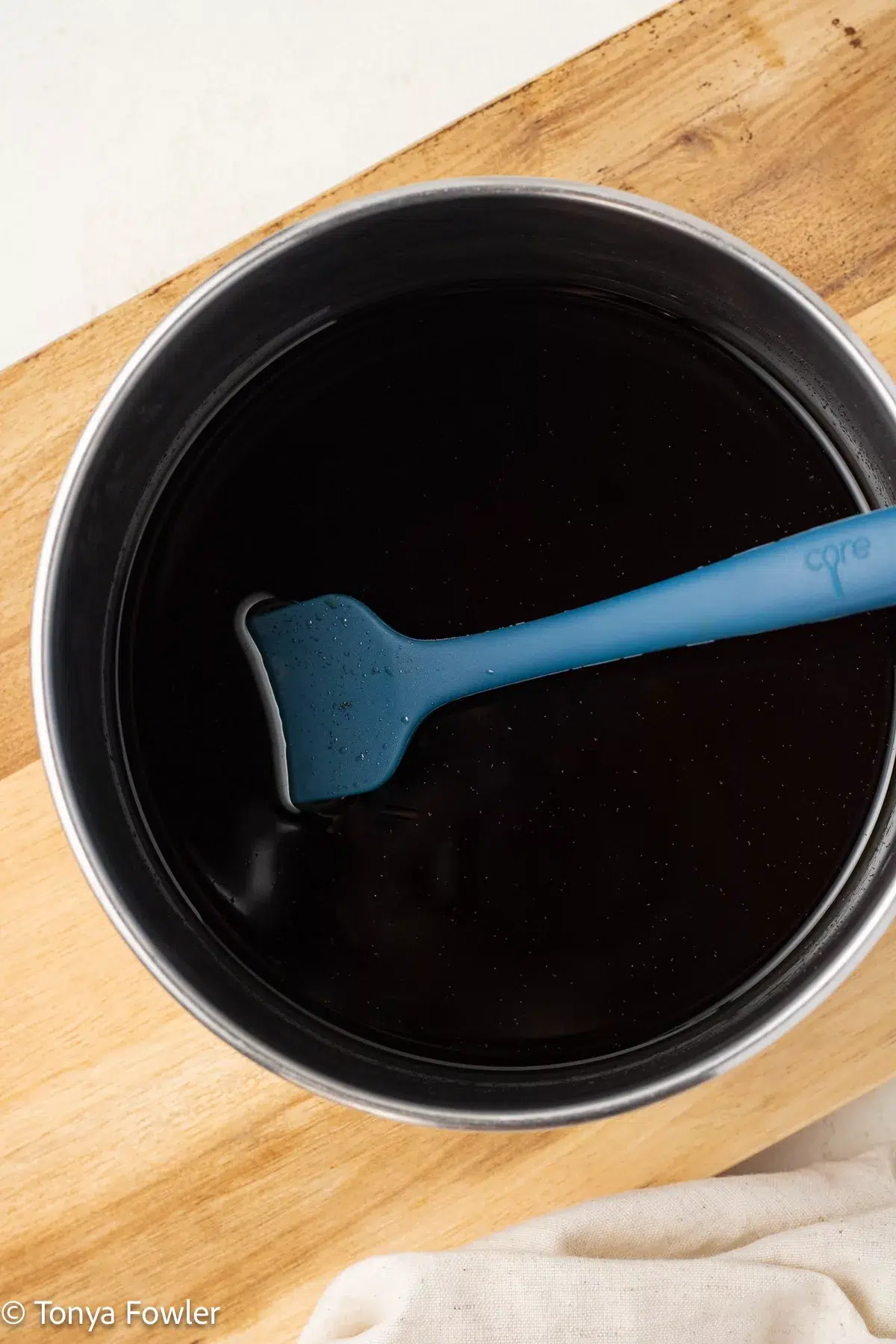 Sugar and water in a pot with a silicone spoon.