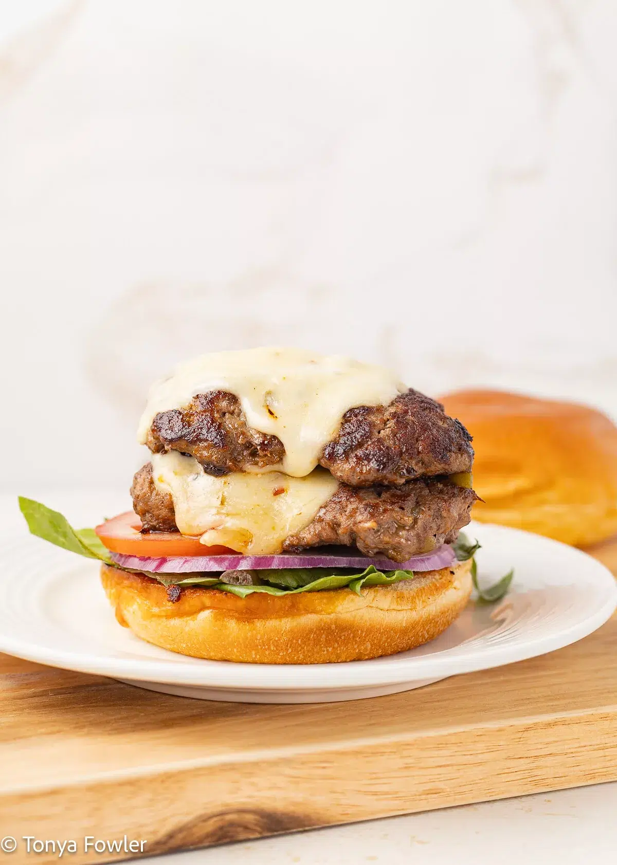 Burger and cheese on sitting on a plate.