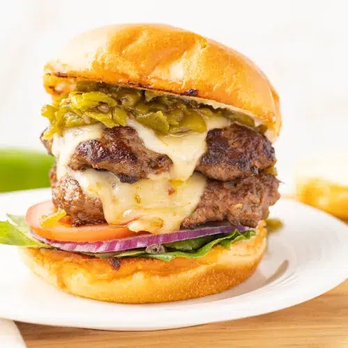 Hatch chile burger with toppings on a plate.