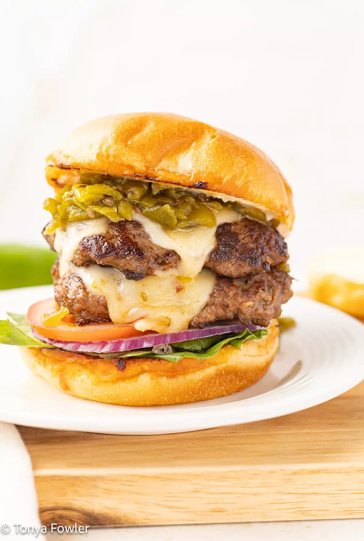 Hatch chile burger with toppings on a plate.