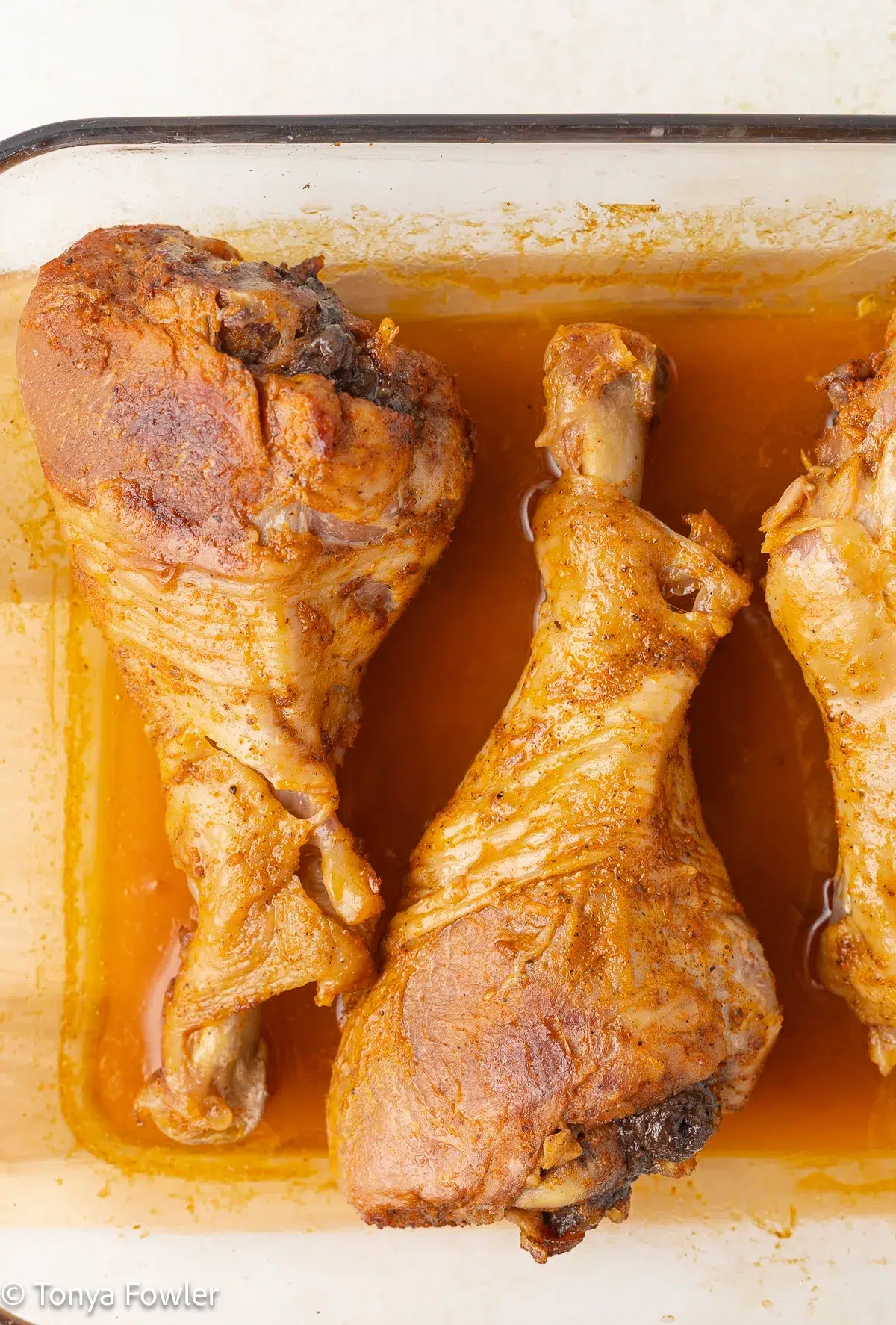 Cooked turkey legs in a baking dish.