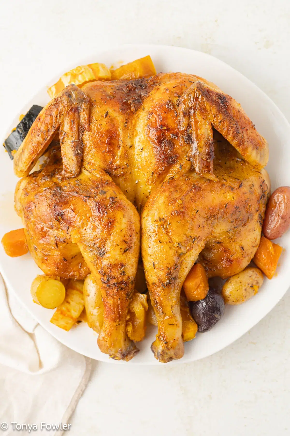 Whole roast chicken on a plate.