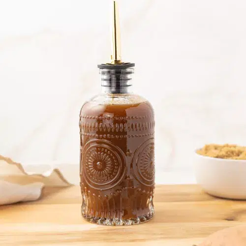 Sweet potato syrup in a jar on a cutting board.