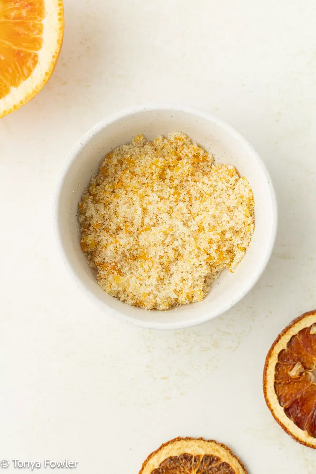 Orange zest mixed with sugar in a bowl.
