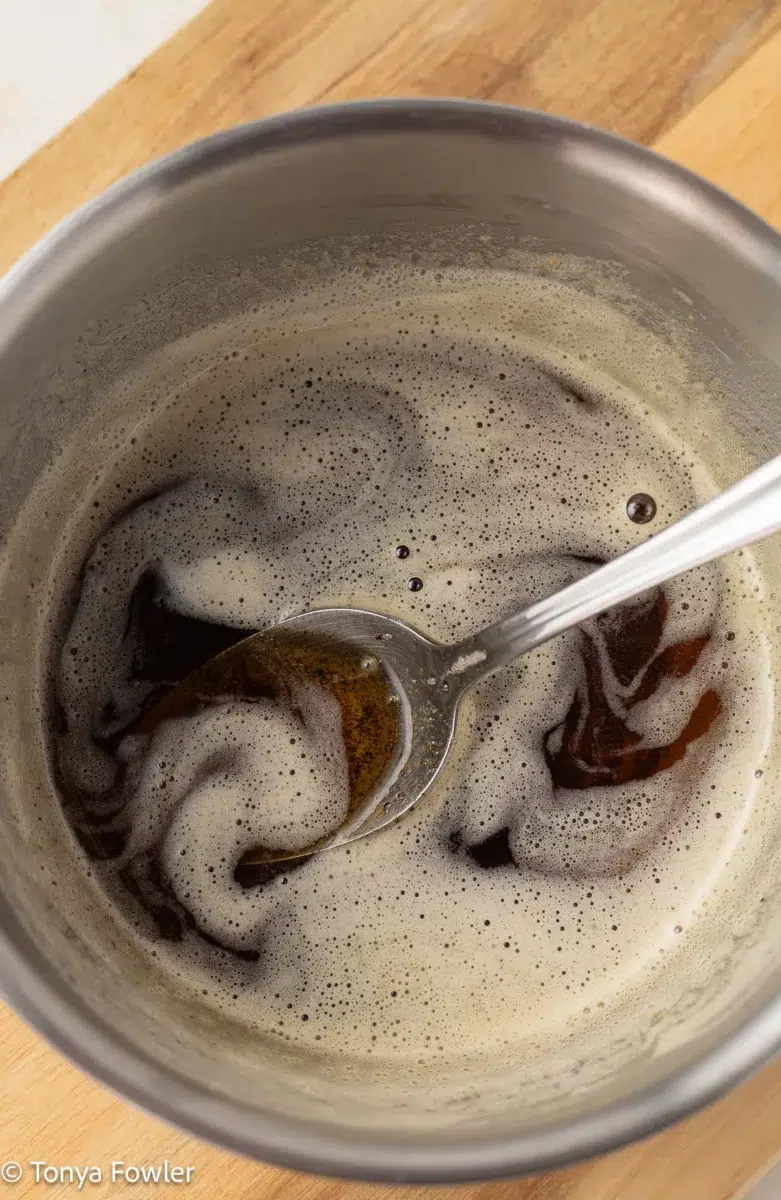 Brown butter in a pot with a spoon.