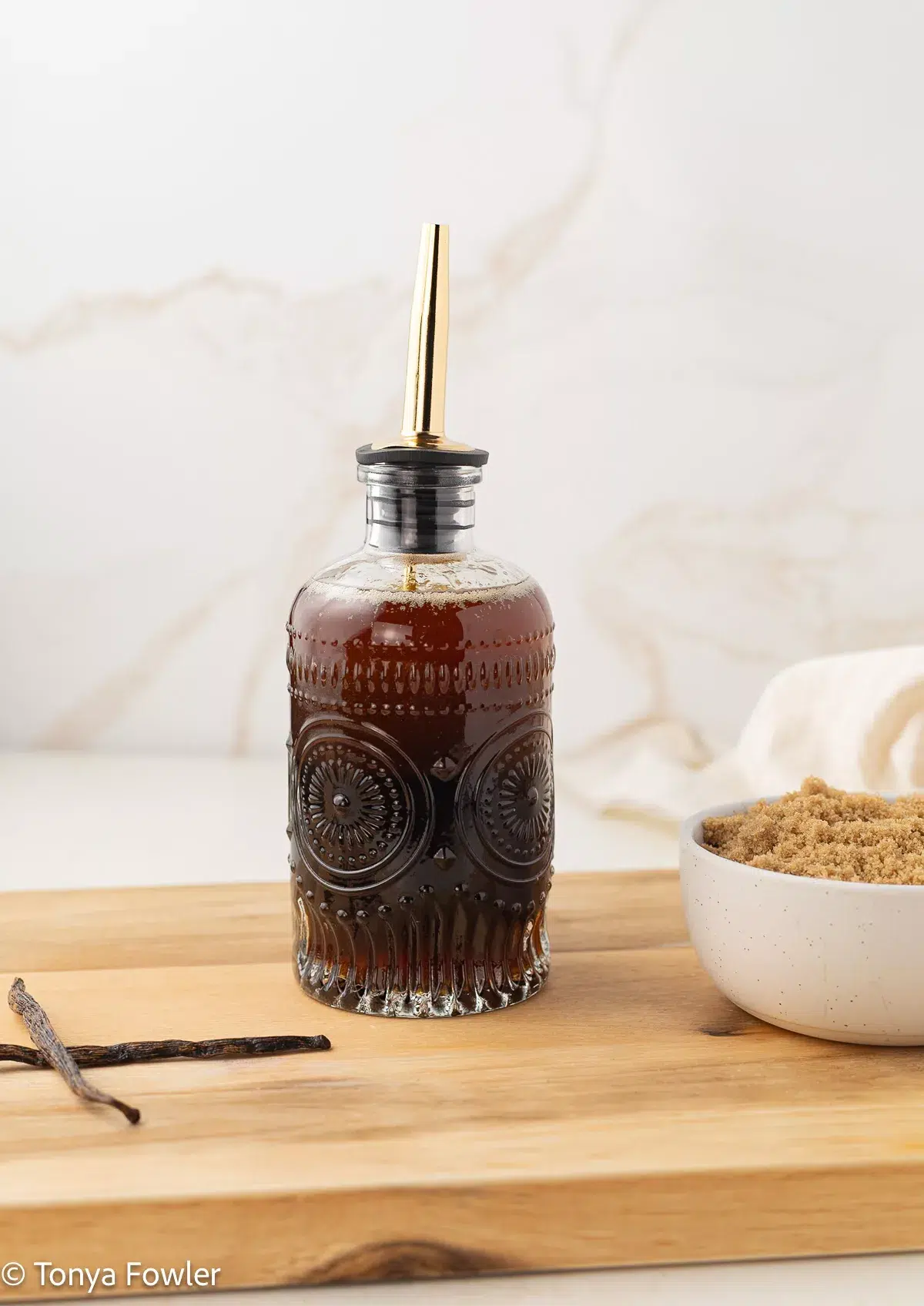 Brown butter vanilla syrup in a glass syrup bottle.