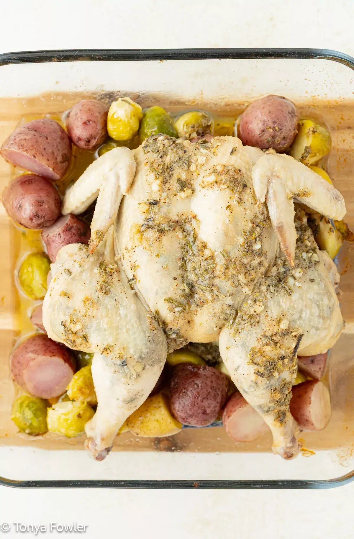 Half baked cornish hen topped with herb butter.