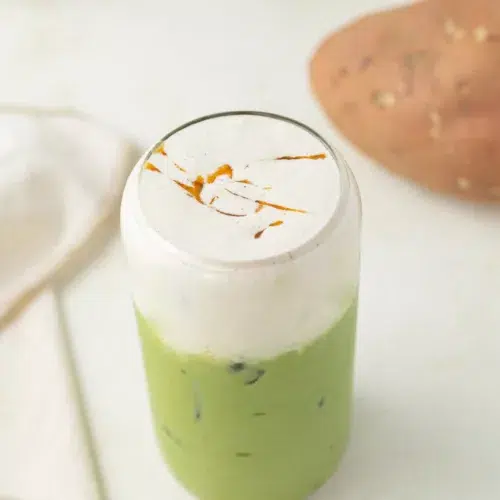 3/4 image of matcha latte topped with cold foam and sweet potato syrup.