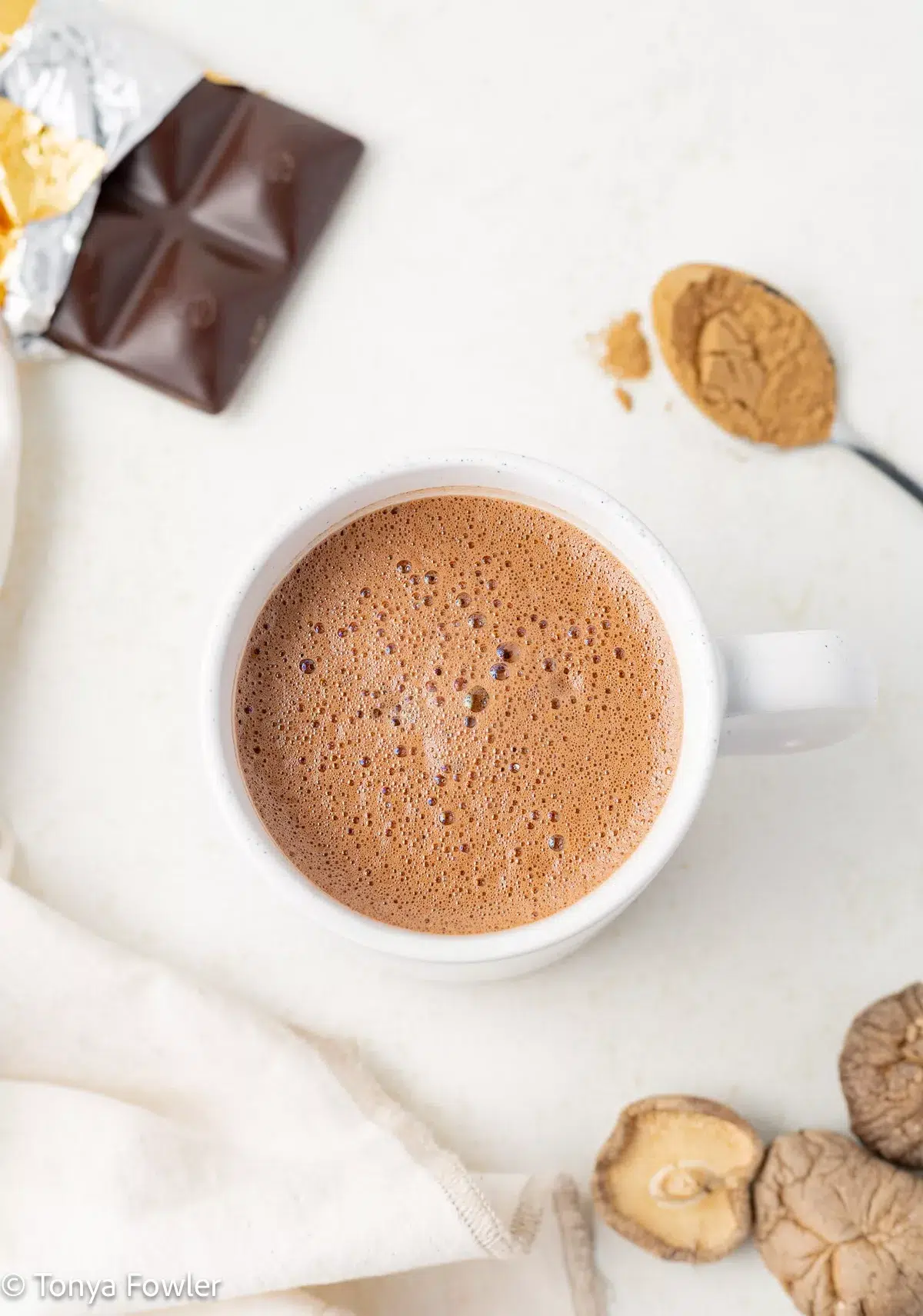 Hot chocolate in a mug with a chocolate bar and dried mushrooms.