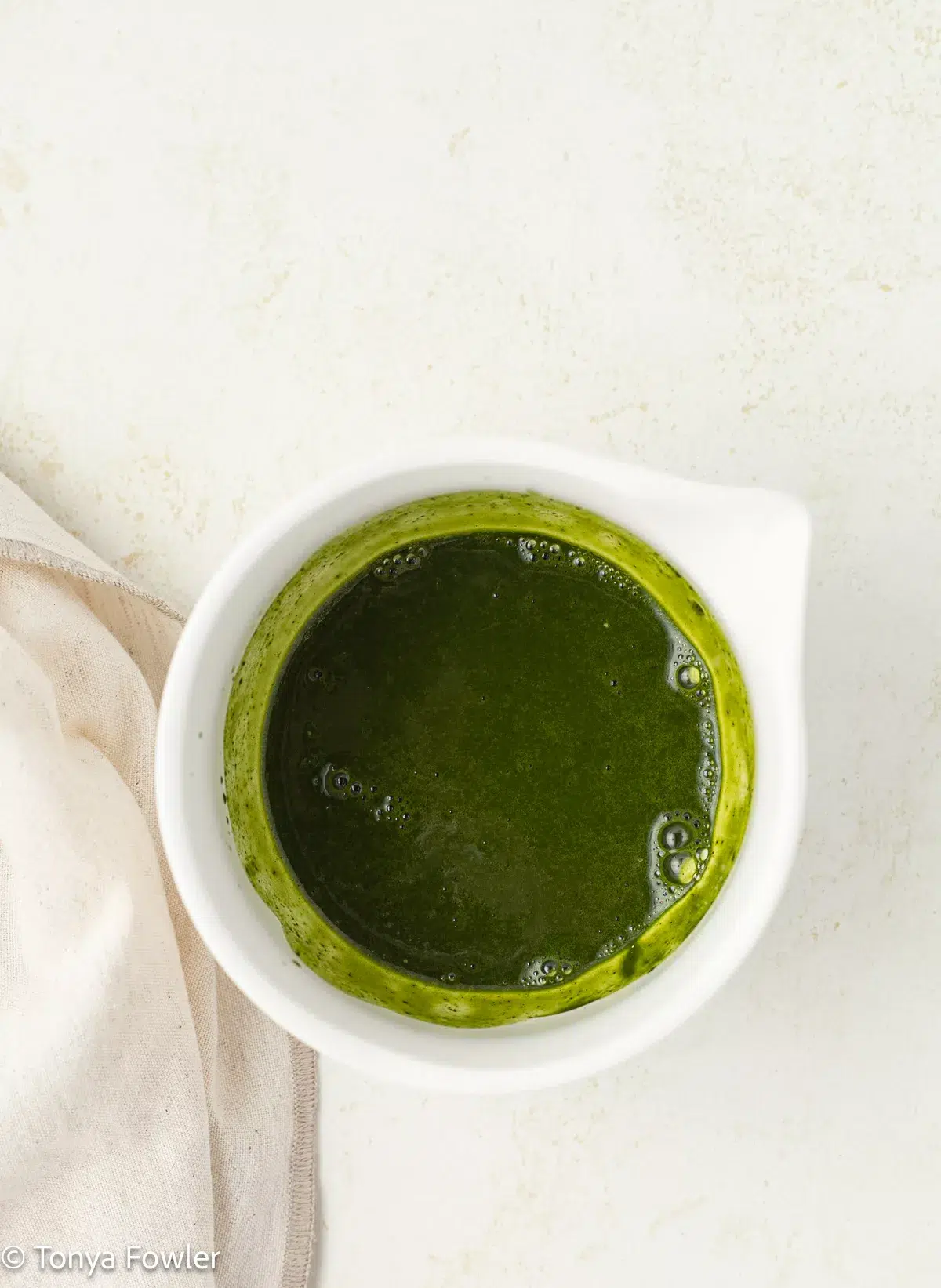 Matcha and vanilla bean paste are mixed together in a matcha bowl.