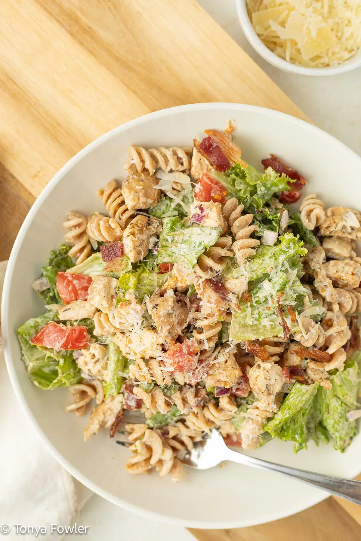 Overhead image of bacon chicken pasta salad on a plate with parmesan cheese.