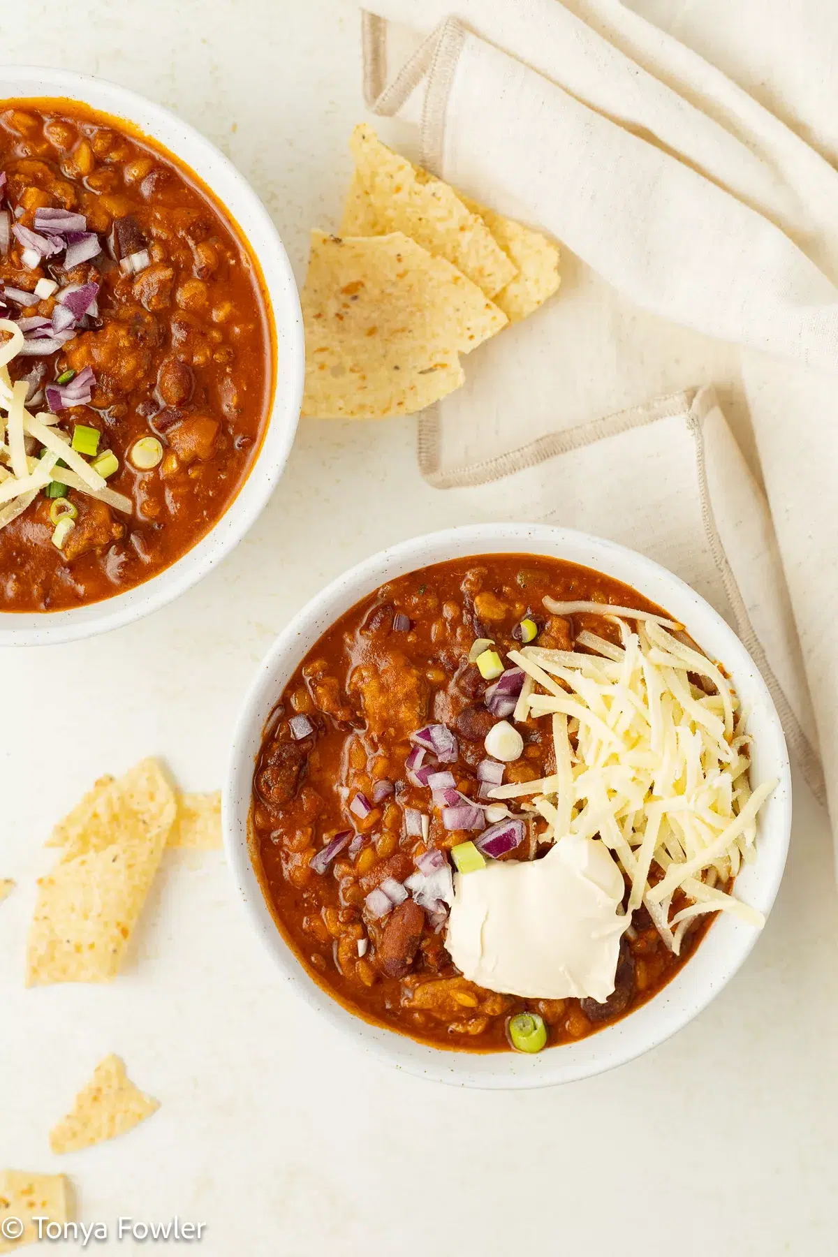 Einkorn Turkey Chili in bowls topped with corn chips and cheese.