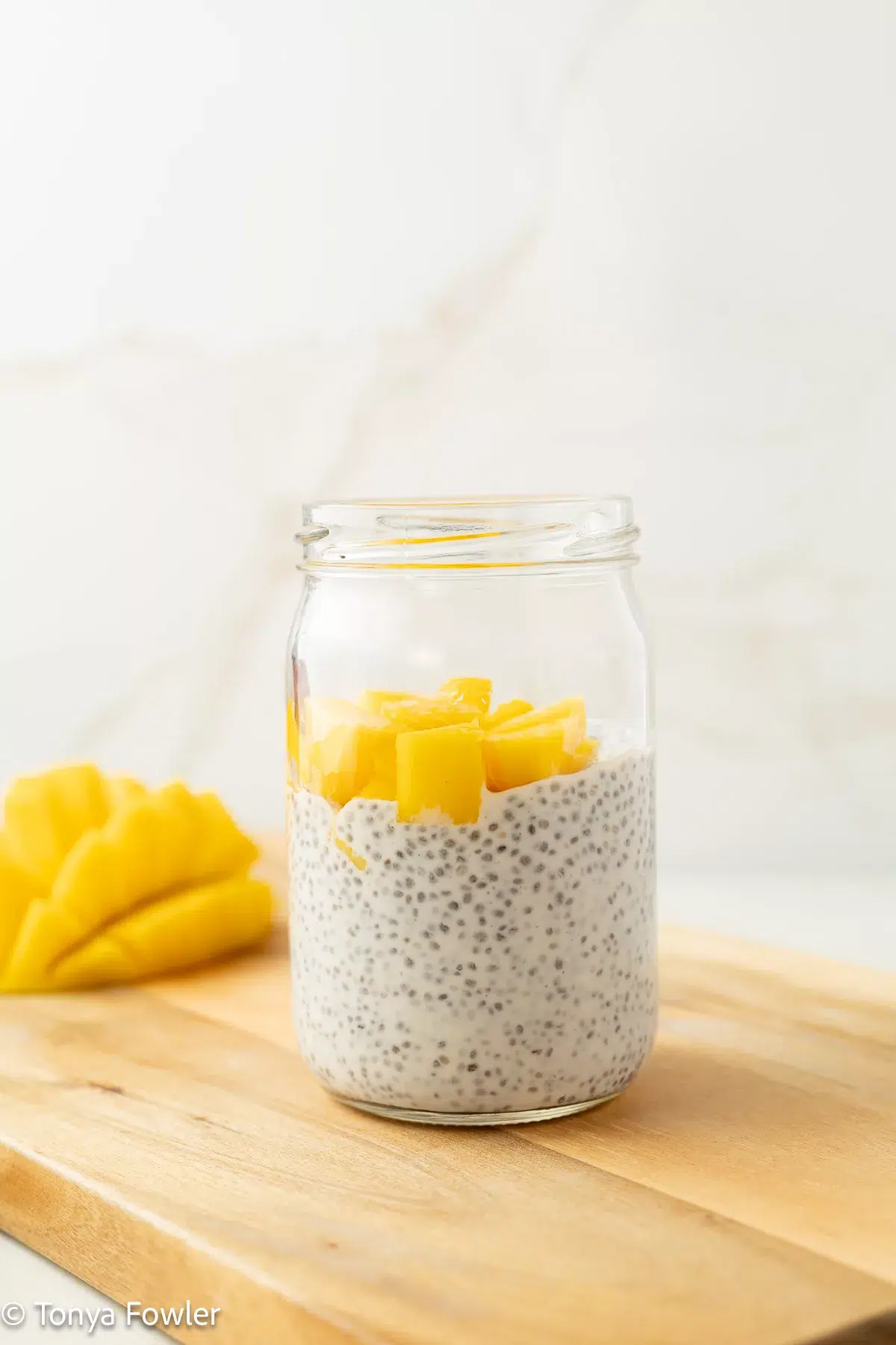 Mango chia pudding topped with fresh mango chunks.