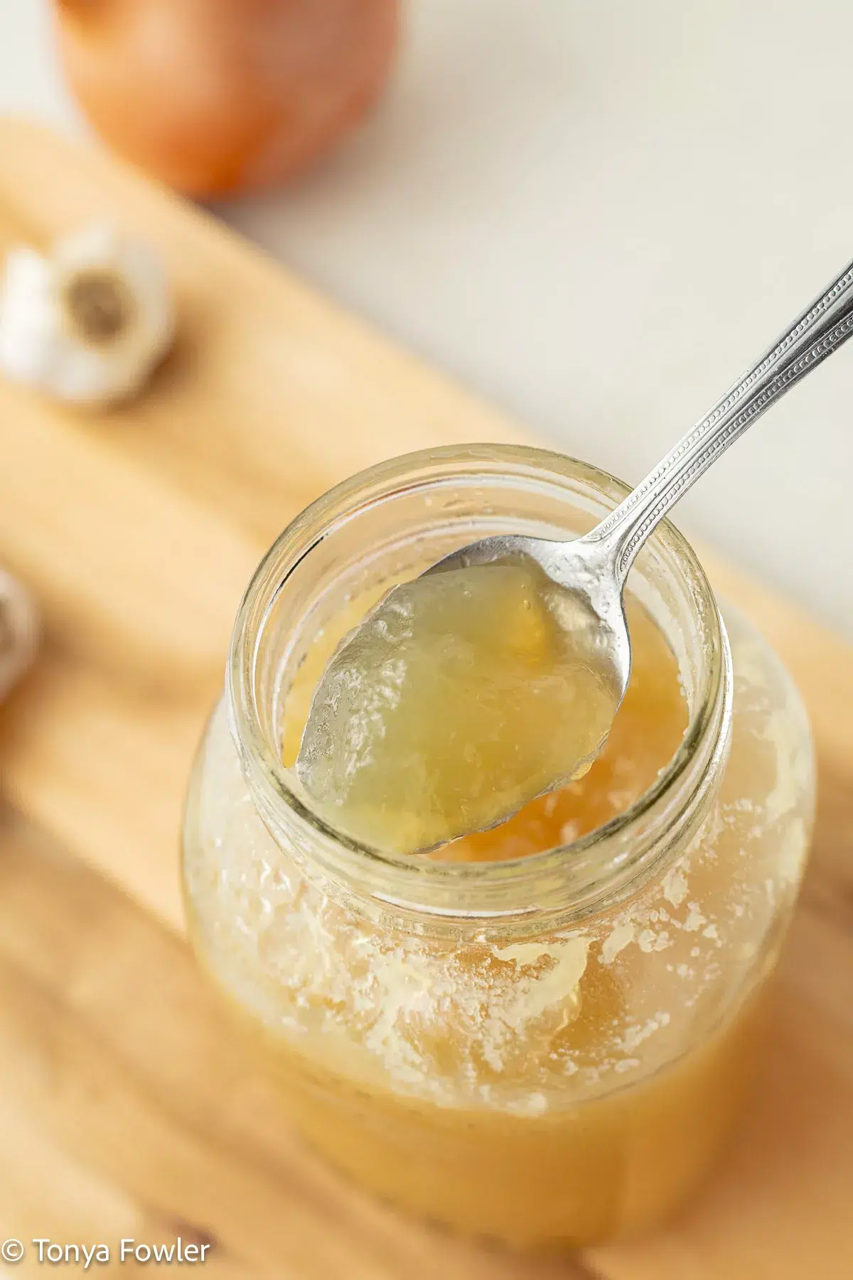 Gelatinous chicken broth on a spoon.