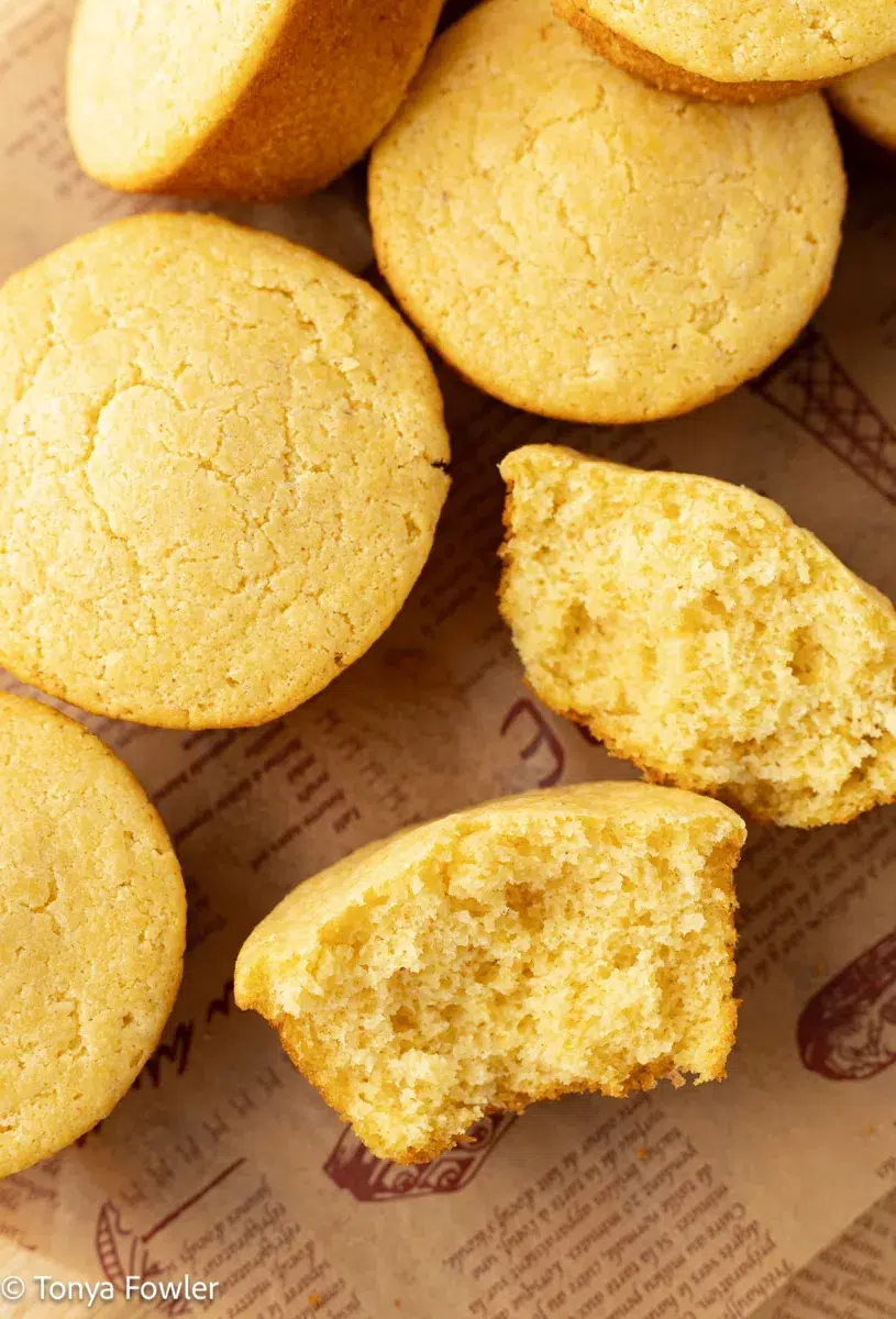 Muffins broken in half on parchment paper.
