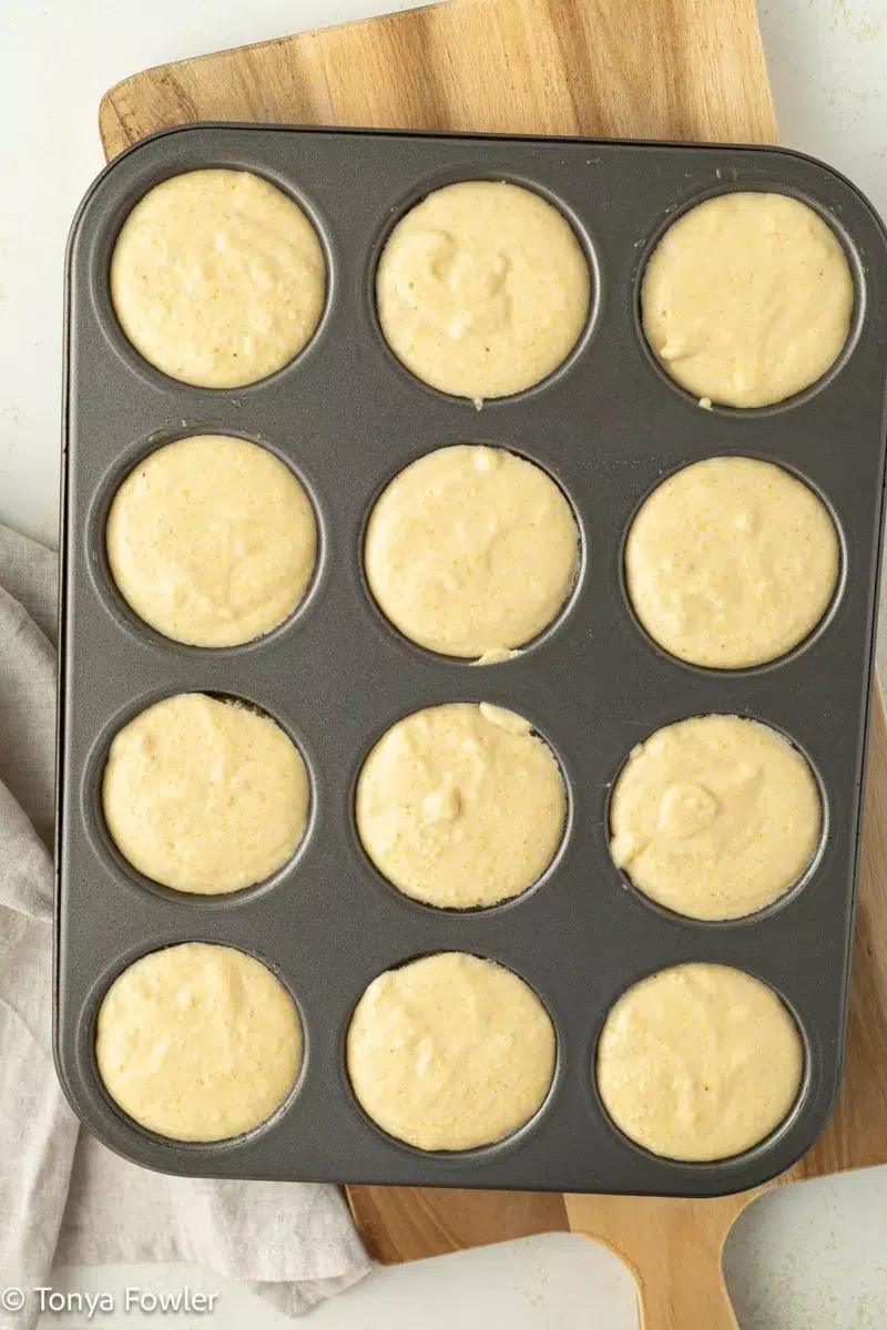 Cornbread batter in a muffin pan.
